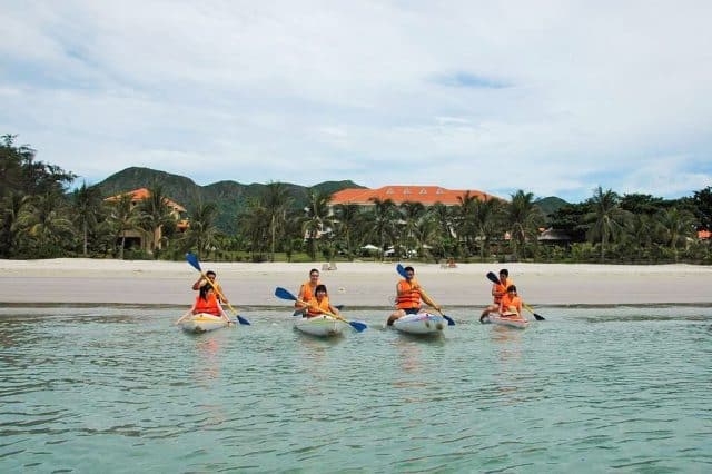 Du khách tham gia trải nghiệm chèo thuyền Kayak tại khu vực bãi tắm riêng của resort 