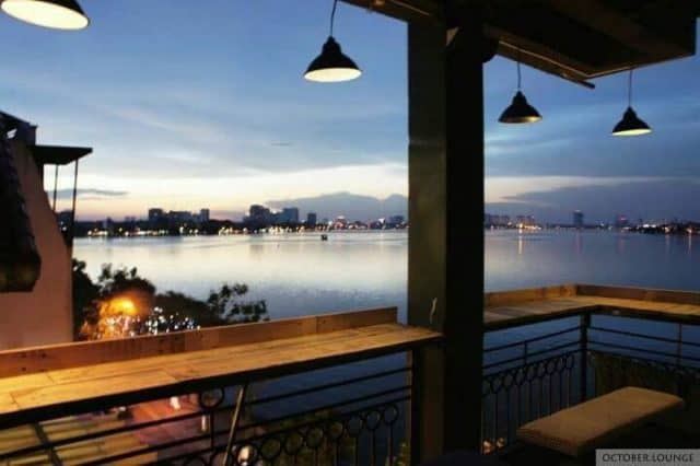 Dãy bàn ngoài ban công tầng 4 với view nhìn thẳng ra Hồ Tây dưới ánh đèn vàng lung linh
