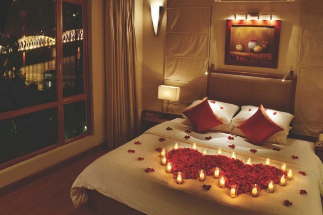 Trang trí giường ngủ với nến và hoa tươi. Ảnh: Internet